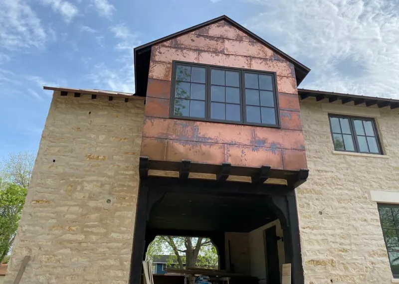 Copper metal panel facade on a stone building for Skylight Installation in Big Rapids